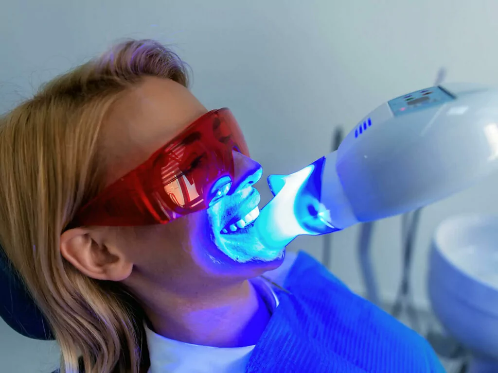 Photo of a woman receiving professional teeth whitening treatment.