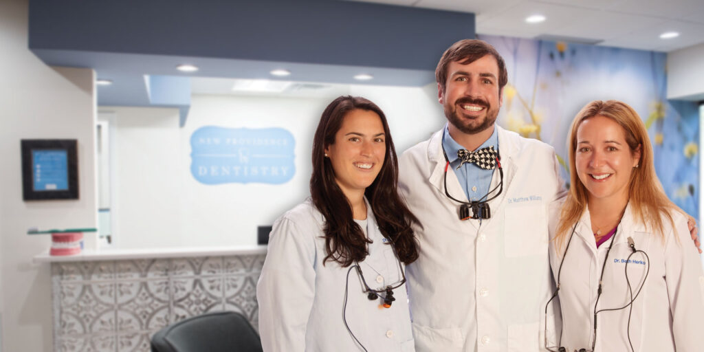 Drs. Malkiewich, Williams, and Herko in front of their dental practice's front office.