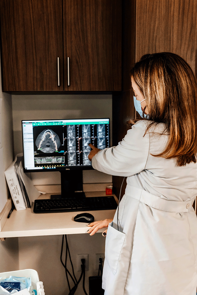 Doctor pointing to x-rays on computer screen