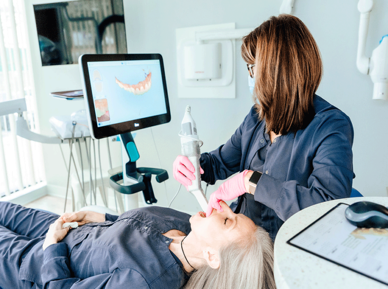 Dental hygienist using an intraoral scanner to create a digital impression of the patient's teeth.