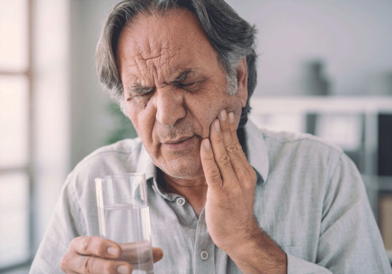 Older man holding his jaw due to severe tooth pain.